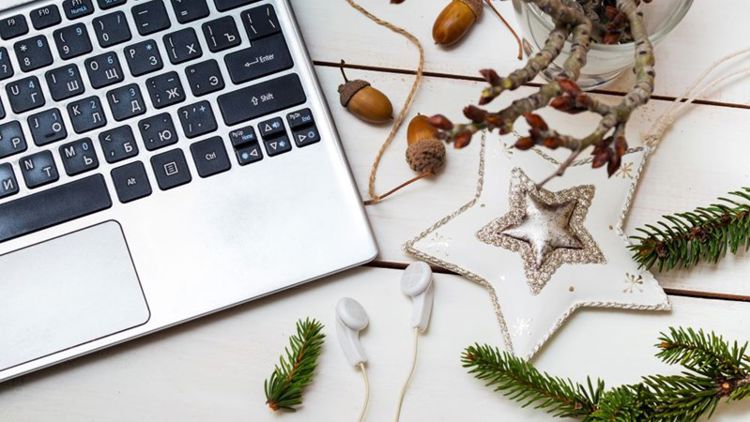 Et tastatur på et bord med julepynt strødd rundt omkring 