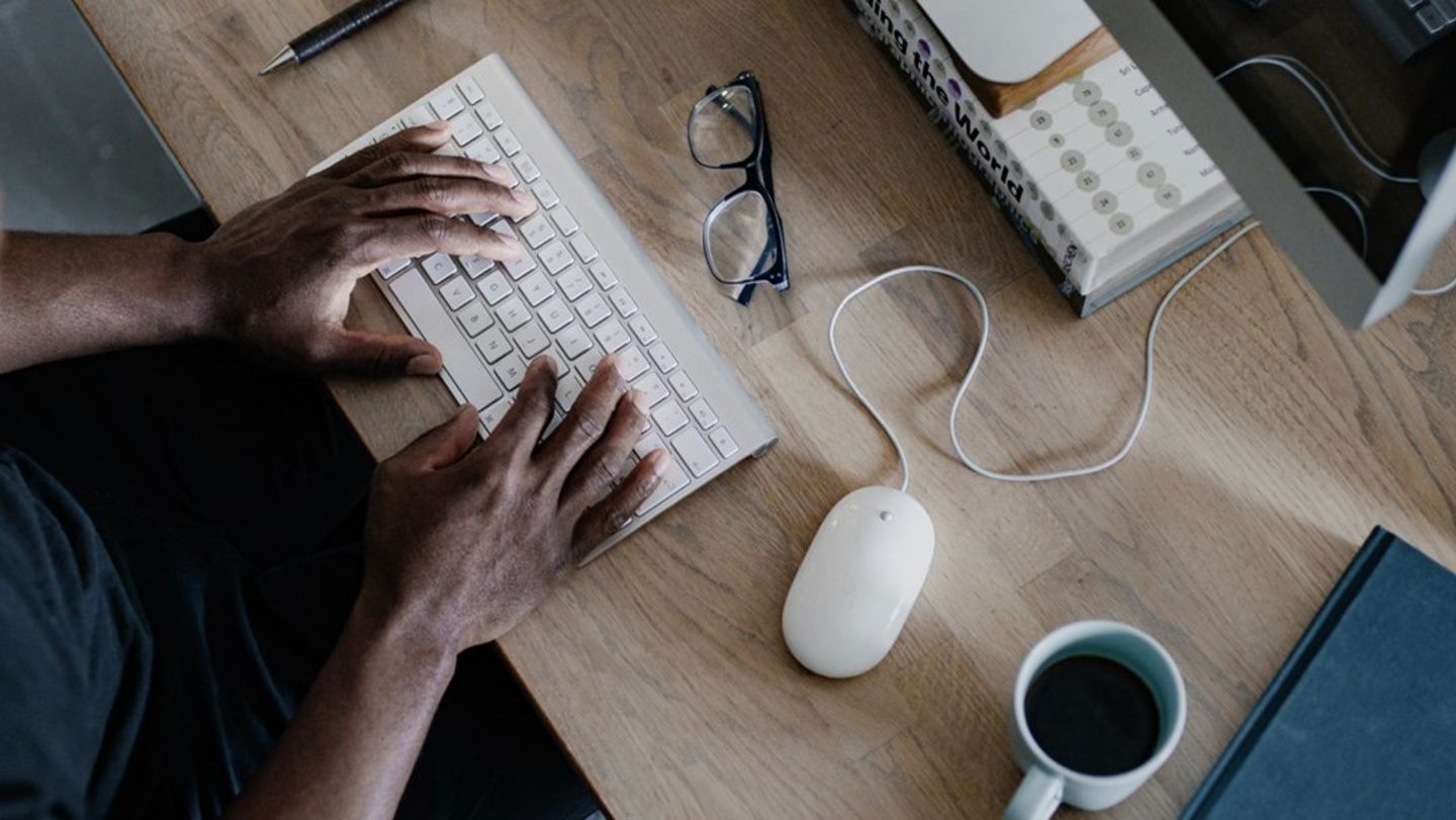 Bilde av hendene til en mann som skriver på tastatur