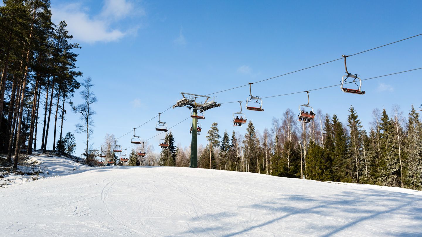 bilde av stolheiser i et alpintrekk i sol 